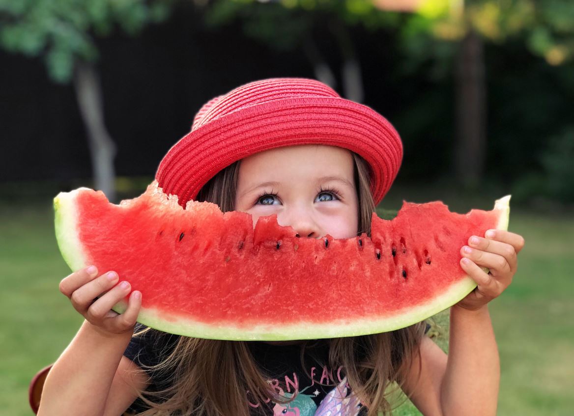 Girl smiling eating a watermelon slice